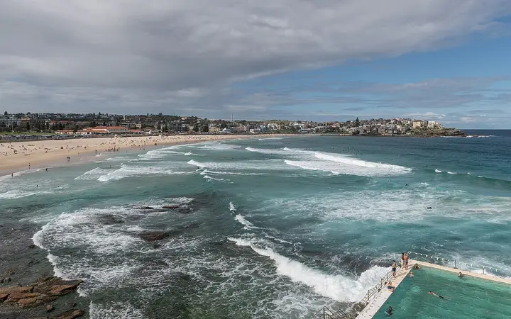 Bondi Beach seen from the south with surf and the Icebergs ocean pool