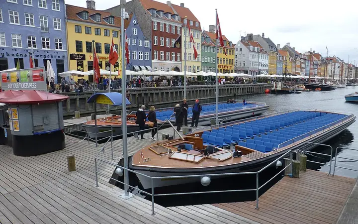 Canal tour boats moored at Nyhavn in front of colourful townhouses