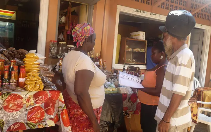Vendors and shoppers at a spice and souvenir stall in Castries Market, Saint Lucia