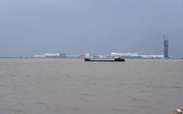 Wusongkou International Cruise Terminal seen across the river, with the T1 and T2 buildings either side of the domed Eye of the Orient