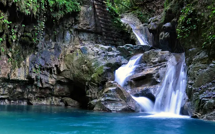 Waterfall cascading into a turquoise pool at Damajagua, Puerto Plata