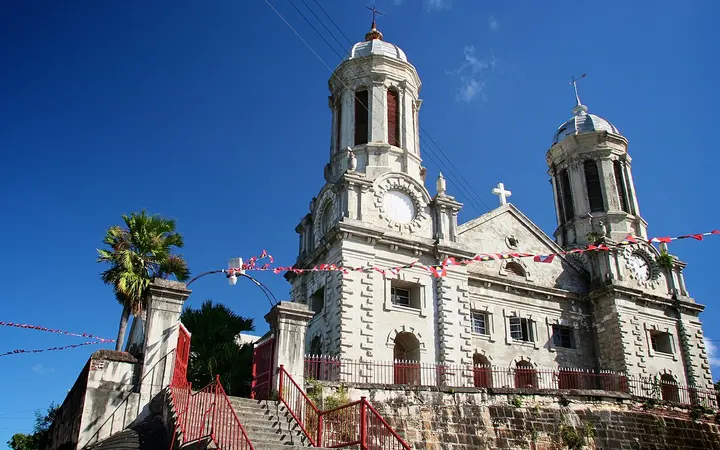 White twin-towered facade of St John's Cathedral, Antigua, with steps and red railings