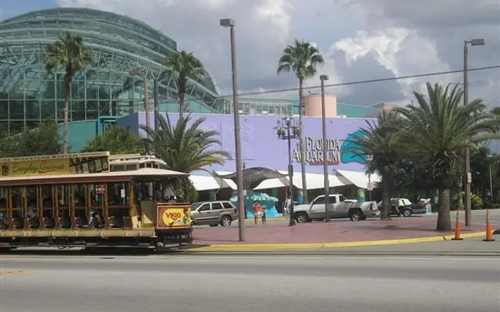 Glass-domed entrance of the Florida Aquarium on Channelside Drive with a TECO streetcar passing