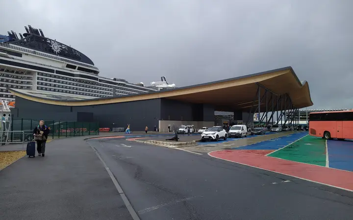 Horizon Cruise Terminal with its curved roof and a cruise ship behind