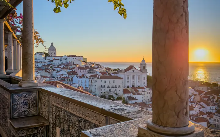 View over Alfama's rooftops toward the Tagus from a terrace