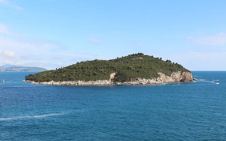 Wooded Lokrum Island with rocky shores in the blue Adriatic off Dubrovnik