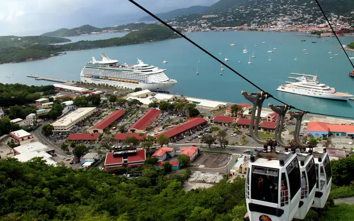 Skyride to Paradise Point gondola cabins above Havensight, with a cruise ship at the WICO dock and Charlotte Amalie harbor behind
