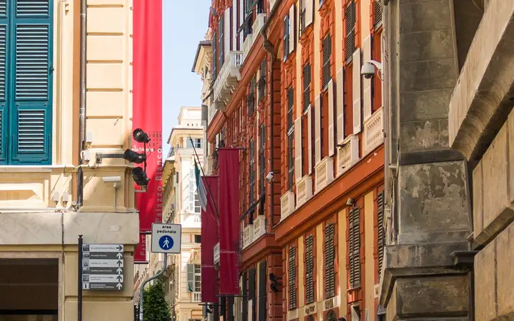 Via Garibaldi in Genoa with the red facade of Palazzo Rosso