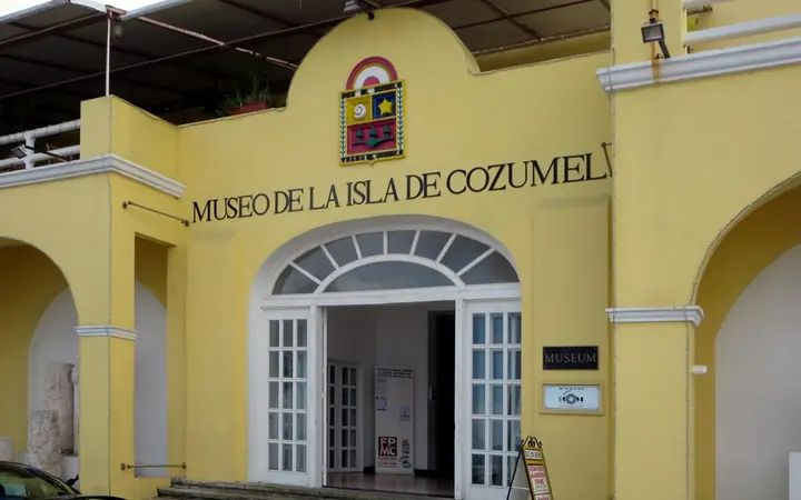 Yellow colonial-style façade of the Museo de la Isla de Cozumel in San Miguel