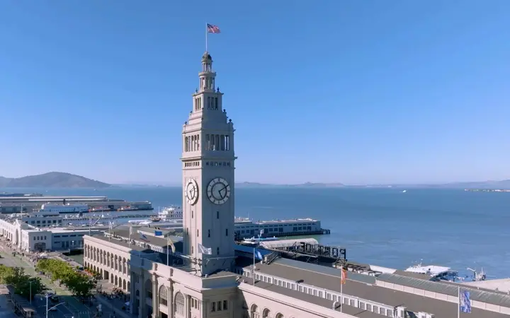 The Ferry Building clock tower on the Embarcadero, with San Francisco Bay and the Bay Bridge beyond