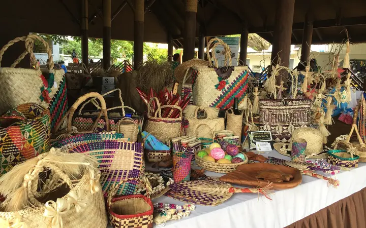 Woven baskets, bags and hats laid out on a stall at a handicraft market in Port Vila