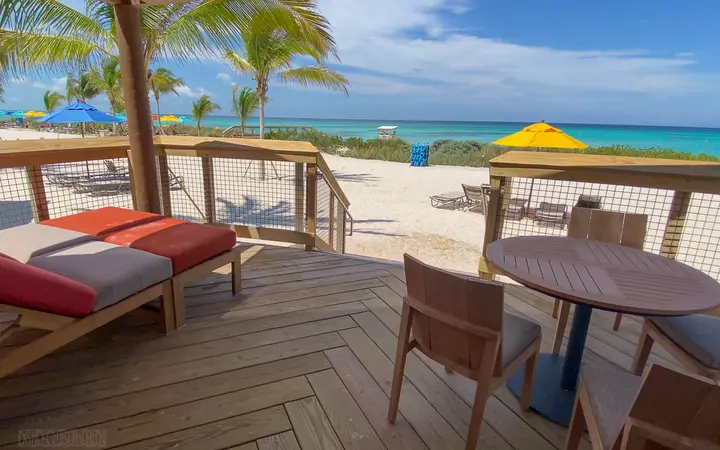 Cabana deck with loungers, table and chairs facing the beach at Serenity Bay, Disney Lookout Cay