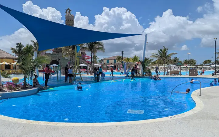 Starfish Lagoon pool with a blue sail shade and palm trees at Celebration Key, Grand Bahama