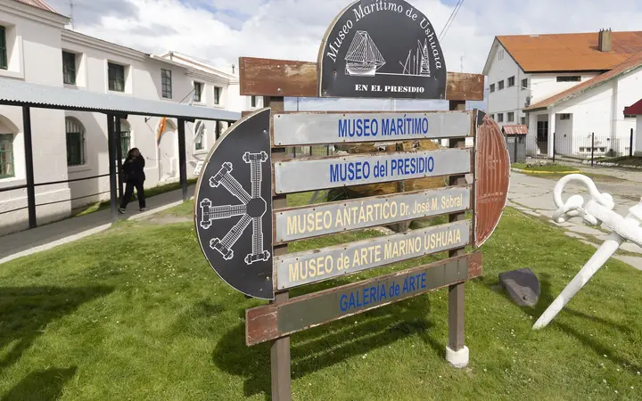 Signpost for the Maritime, Prison and Antarctic museums outside the white former prison buildings in Ushuaia.